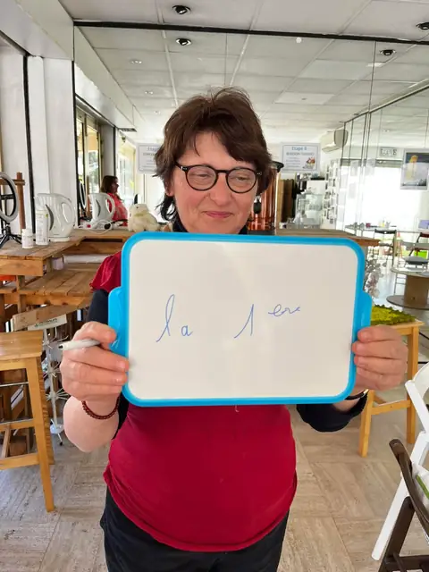Le sourire aux lèvres, une membre dévoile ses chiffres du jour inscrits sur l’ardoise